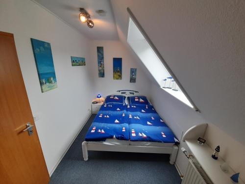 a bedroom with a bed with a blue comforter at Whg Meeresblick in Nieblum