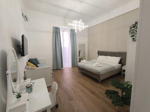 a bedroom with a bed and a desk in a room at DIMORA FASANO in Bari