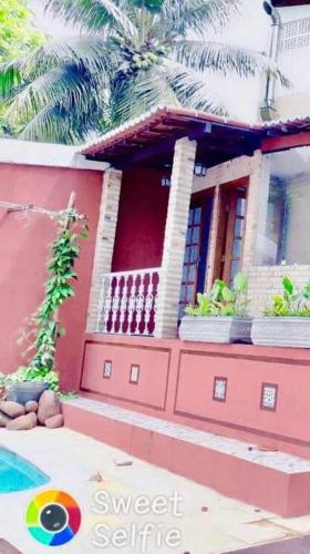 a red house with palm trees in front of it at Pousada Saruê Praia de Ponta Negra Natal RN in Natal