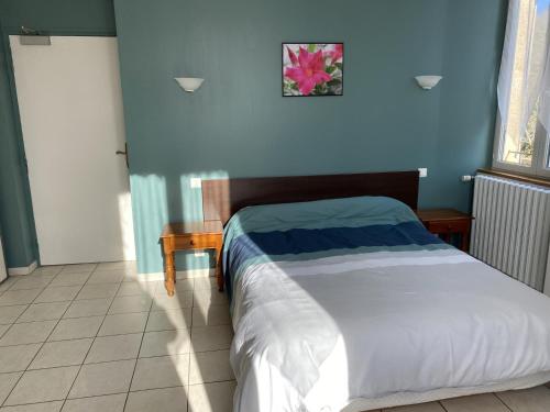 une chambre avec un lit et un mur bleu dans l'établissement Le renaissance, à Latouille-Lentillac