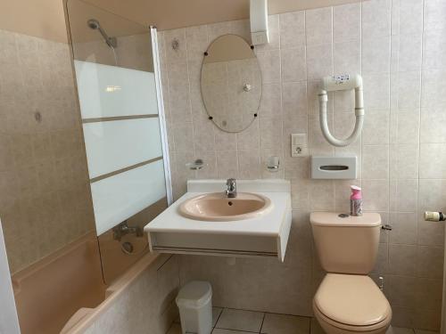 une salle de bain avec un lavabo, des toilettes et un miroir dans l'établissement Le renaissance, à Latouille-Lentillac