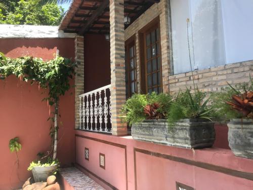 a balcony of a house with potted plants on it at Pousada Saruê Praia de Ponta Negra Natal RN in Natal