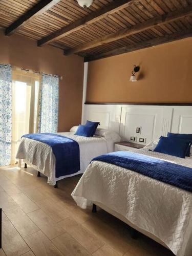 a bedroom with two beds with blue sheets at Apartamento 1 Premiere de Occidente in Quetzaltenango