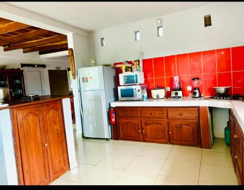 a kitchen with wooden cabinets and a refrigerator at Villa baobab in Ramena