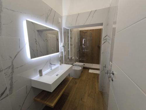 a white bathroom with a sink and a toilet at DIMORA FASANO in Bari