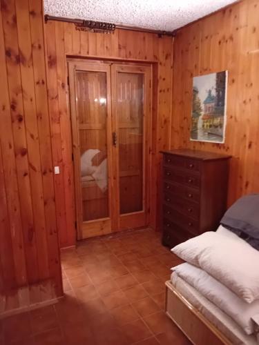 a bedroom with wooden walls and a bed and a dresser at Monolocale campo d'altura in Rieti