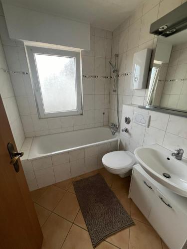 a bathroom with a tub and a toilet and a sink at Ferienwohnung in Bad Honnef in Bad Honnef am Rhein