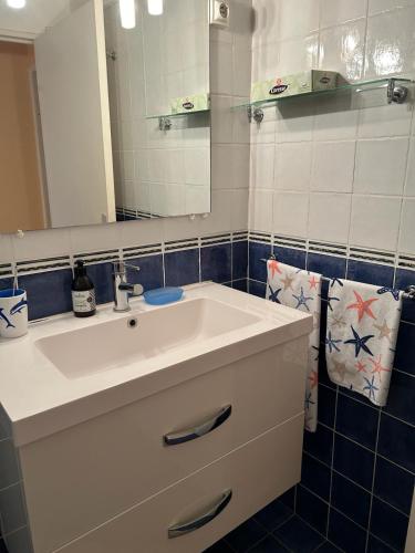 une salle de bain avec un lavabo blanc et un miroir dans l'établissement LA BLUETTE - Appartement T2 - PLAGE de PEGUIERE - ST RAPHAËL, à Saint-Raphaël