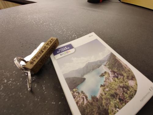 a book on a table with a pen and a picture at Casa Vacanze - Green Garden in Ledro