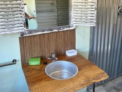 a bathroom with a wooden counter with a sink at Tin Can Glamping Caravan in Underberg