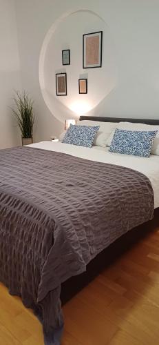 a bedroom with a large bed with blue pillows at Apartments Klementina in Postira