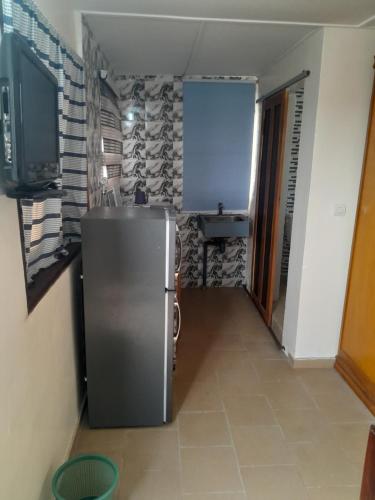 a small kitchen with a refrigerator in a room at Casa Djoko in Dakar