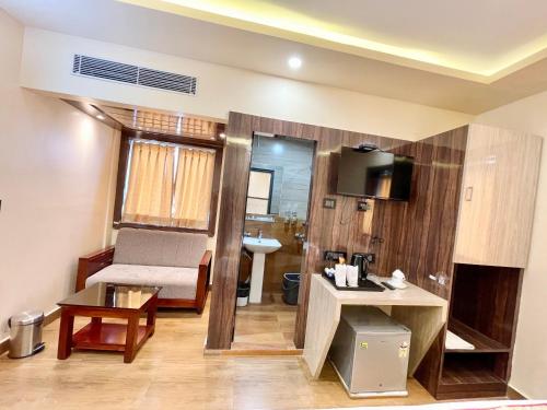 uma sala de estar com um sofá e um lavatório num quarto em Hotel A ONE pride ! Puri fully-air-conditioned-hotel near-sea-beach-&-temple with-lift-and-parking-facility restaurant-availability em Puri