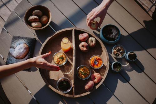 a table with food on top of a table with people pointing at food at AQVA Boutique Hotel (Adults Only) in Sirmione