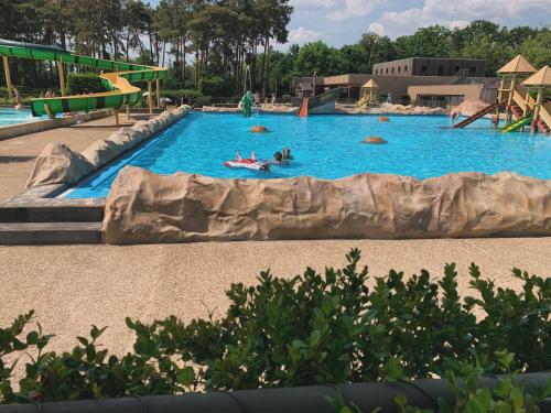 ein großer Pool mit Menschen im Wasser in der Unterkunft Ecolodge Over the Rainbow in Bocholt