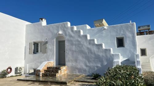 a white house with a staircase leading up to it at Krios Guesthouse in Krotiri