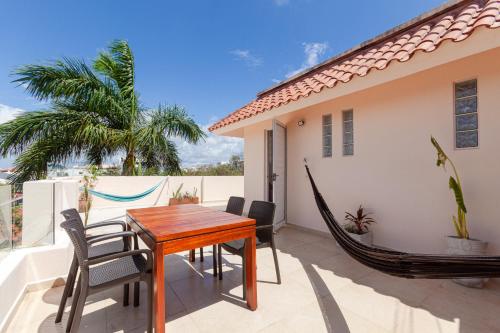 a patio with a table and chairs and a hammock at Via Tendenza Condos in Playa del Carmen