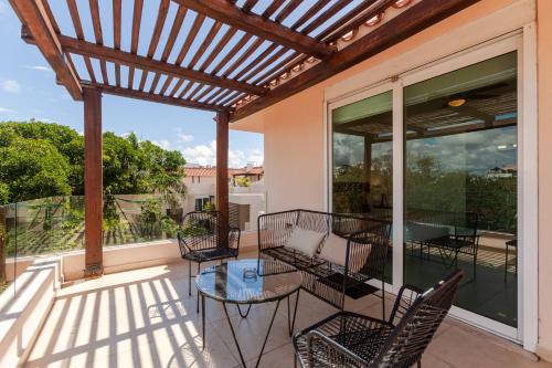 a patio with chairs and a table on a balcony at Via Tendenza Condos in Playa del Carmen