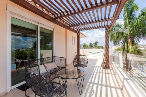 a patio with chairs and a table on a balcony at Via Tendenza Condos in Playa del Carmen