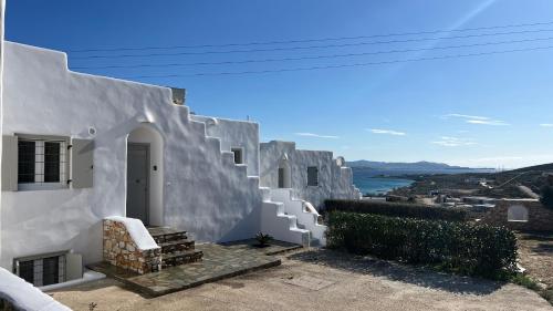 a white house with white stairs and a view at Krios Guesthouse in Krotiri
