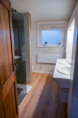 a bathroom with a sink and a window and a tub at Le Colibri spa jacuzzi in Durbuy