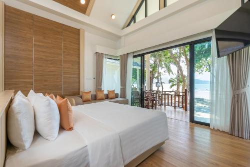 a bedroom with a large white bed with a large window at Koh Chang Paradise Resort & Spa in Ko Chang