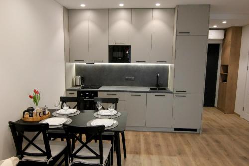 a kitchen with a table and chairs in a room at Warmzy Home - Modern 2 Rooms Apartment With Free Parking in Vilnius
