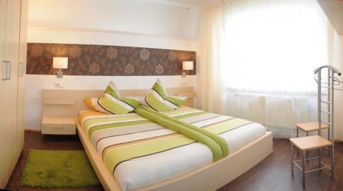 una camera da letto con un letto grande con cuscini verdi di Haus Hippelstein a Gönnersdorf