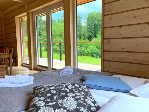 1 dormitorio con cama y ventana grande en 3pokoje - domek pod lasem na odludziu en Susiec