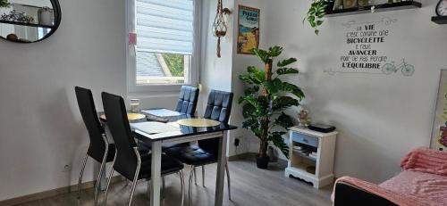 une salle à manger avec une table et quatre chaises dans l'établissement Appartement avec terrasse proche plages et sentiers de randonnée, à Perros-Guirec