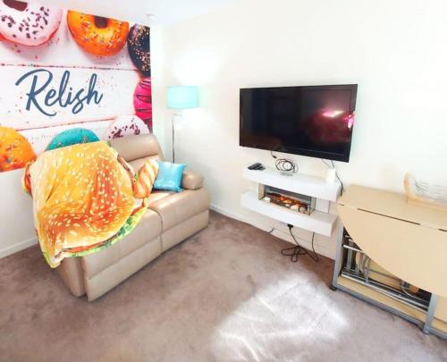 a living room with a couch and a flat screen tv at The Relish - ground floor flat in Largs in Largs