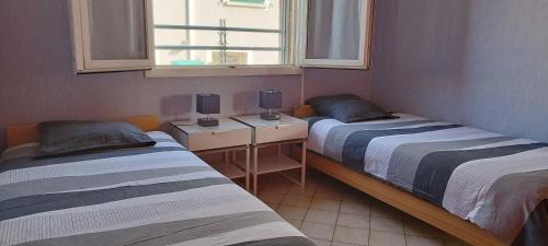une chambre avec deux lits et une fenêtre dans l'établissement Appartement T3 Spacieux avec vue sur l'étang de Thau au 1er étage d'une villa - entrée indépendante, à Sète