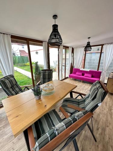 a dining room with a wooden table and chairs at Happy House in Kranevo