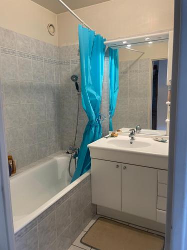 La salle de bains est pourvue d'un lavabo blanc et d'une baignoire. dans l'établissement BeconLesBruyeres, à Courbevoie