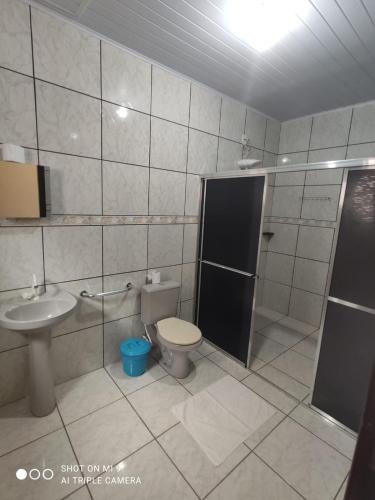 a bathroom with a toilet and a shower and a sink at Hotel Pousada Bela Manhã in Pôrto Primavera