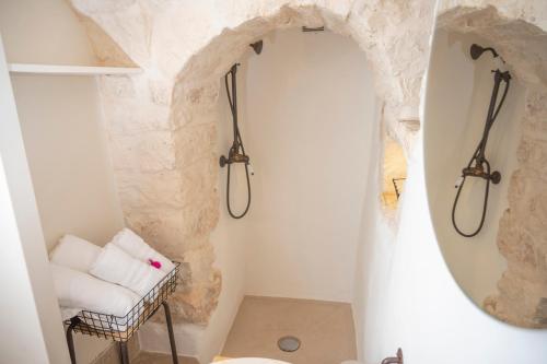 a bathroom with a stone wall and a shower at B&B TRULLI MIRIVA' in Alberobello