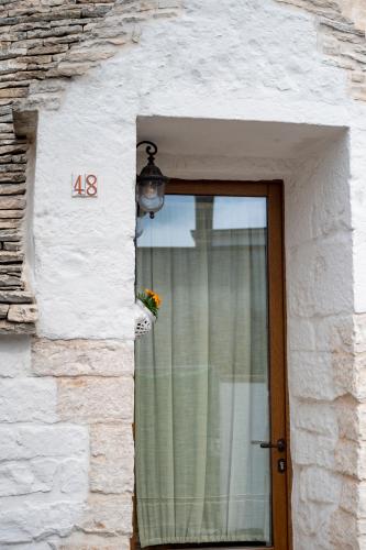 a door with a window with a flower on it at B&B TRULLI MIRIVA' in Alberobello