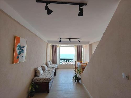 uma sala de estar com um sofá e vista para o oceano em Appartement T2 avec terrasse et Vue mer à Béjaïa proche plage em Bejaïa