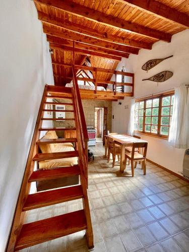 Cette chambre dispose d'un escalier en bois et d'une table. dans l'établissement Casa para descansar, à San Carlos de Bariloche