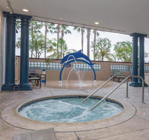 una piscina profunda con una fuente en un edificio en Peacock Suites, en Anaheim