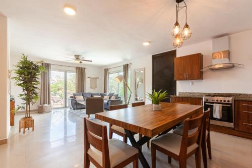a kitchen and living room with a wooden table and chairs at Via Tendenza Condos in Playa del Carmen