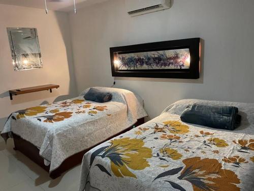 a bedroom with two beds and a picture on the wall at Casa vacacional los olivos in San Blas