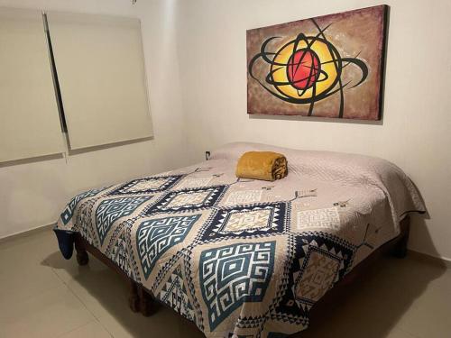 a bed in a room with a painting on the wall at Casa vacacional los olivos in San Blas