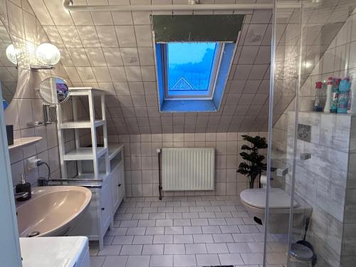 a bathroom with a sink toilet and a window at Ferienwohnung Landliebe in Ihlow