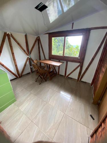 an attic room with a table and a window at Cabaña rural con piscina in Manizales
