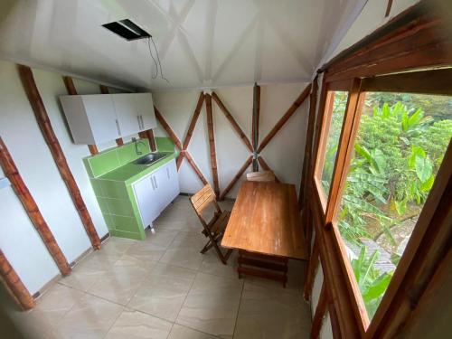 a small kitchen with a table and a sink in a room at Cabaña rural con piscina in Manizales