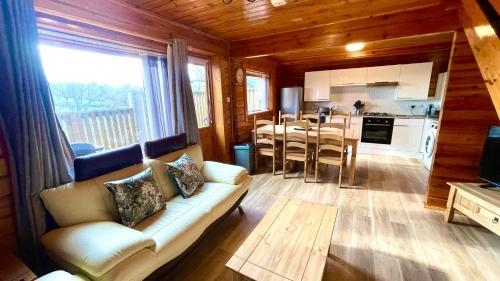 un soggiorno con divano bianco e una cucina di Cowslip Lodge - Your Peaceful Retreat in South Devon a Chudleigh