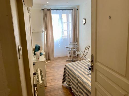 a room with a bed and a table and a window at Operappart 2 in Toulon