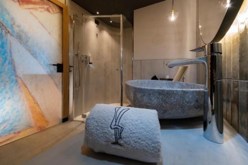 a bathroom with a sink and a bath tub at Locanda degli Artisti Art Hotel in Canazei