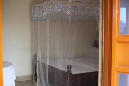 a bedroom with a bed with a curtain at DAR Guest House in Kabarole